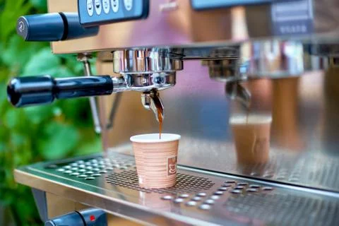 Coffee machine preparing fresh coffee and pouring into paper cup Stock Photos