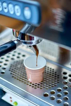 Coffee machine preparing fresh coffee and pouring into paper cup Stock Photos