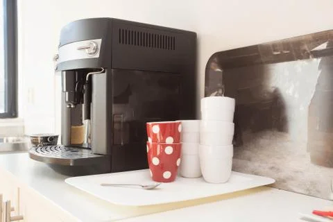 Coffee machine preparing fresh coffee and pouring into red cups at restaurant Stock Photos