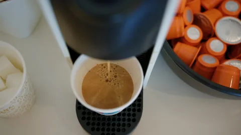 Coffee machine preparing a fresh espresso shot into a disposable cup, surrounded Stock Footage 342757789