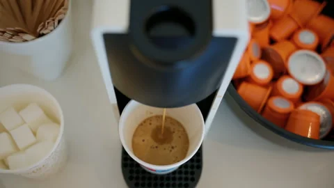 Coffee machine preparing a hot espresso in a disposable cup, with sugar cubes Stock Footage 342757529