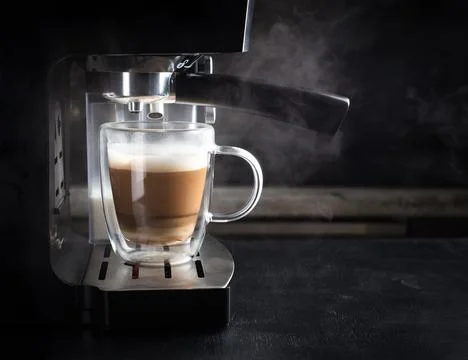 Coffee machine with steam in the process of making coffee. Coffee barista. Stock Photos