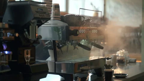 Coffee machine is on table in kitchen and employee works nearby indoors spbas. Stock Footage 157821012