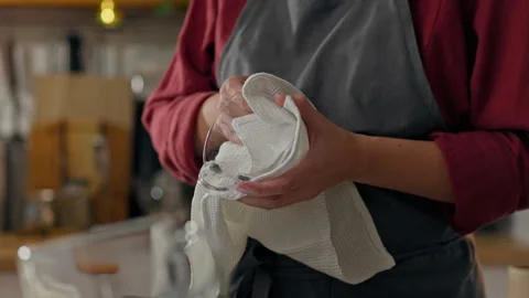 Coffee machine, the worker carefully wipes the glass cup behind the bar. Slo Stock Footage 247018636