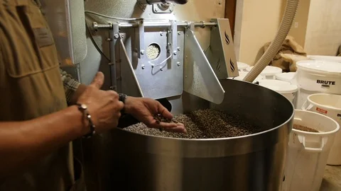 Coffee machine worker is standing near roasting machine Stock-Footage 122590275