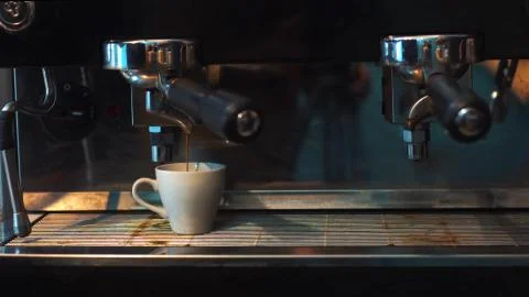 Coffee made in professional espresso machine pouring into a cup. Stock Photos