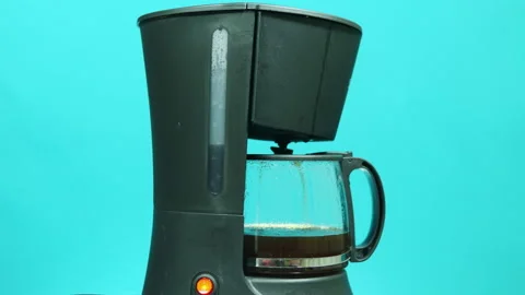 The coffee maker brews coffee on a turquoise background. Time-lapse Stock Footage 139061944