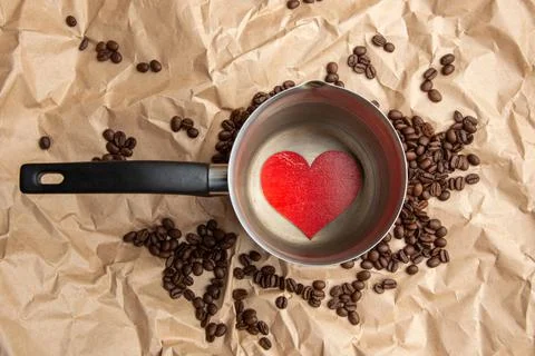 A coffee maker filled with coffee beans With a heart at the bottom coffee lov Stock Photos