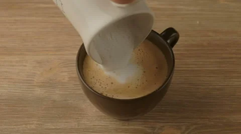 Coffee maker pouring hot milk in cup to prepare cappuccino Stock Footage 67512283