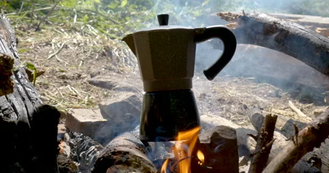 The coffee maker prepares coffee over the fire Stock Footage 156600352