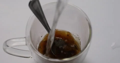 Coffee making process, water is pouring into a glass mug, close-up,coffee is Stock Footage 147317181