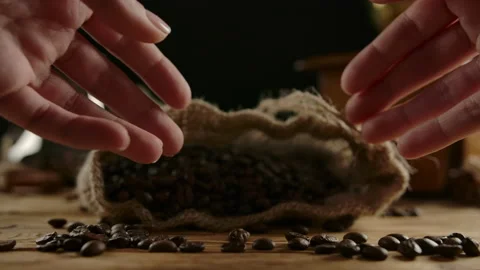 Coffee manufacturing process. Get roasted beans out of traditional burlap bag Stock Footage 138522404