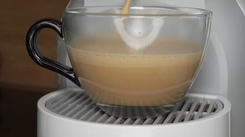 Coffee with milk being poured in transparent cup with capsule coffee mashine Stock Footage 88988443