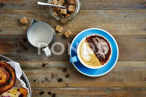 Coffee with milk foam, sugar cubes and a puff pastry Stock Photos