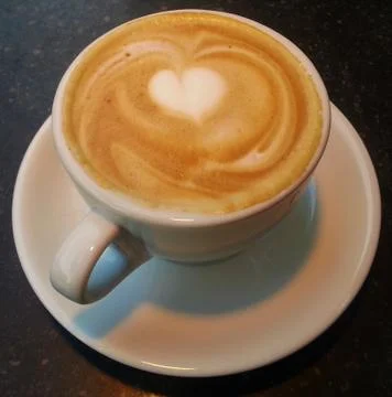 Coffee with milk foam on the table Stock Photos