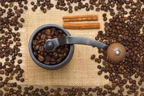 Coffee mill full coffee beans on sackcloth Stock Photos