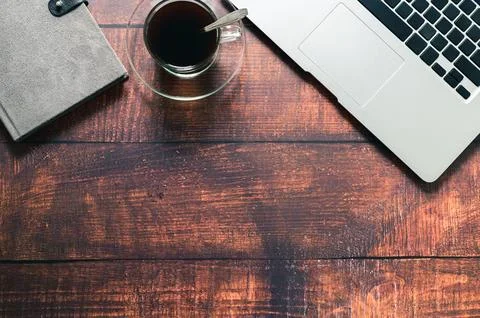 Coffee mug, notebook computer, book at the desk. Stock Photos