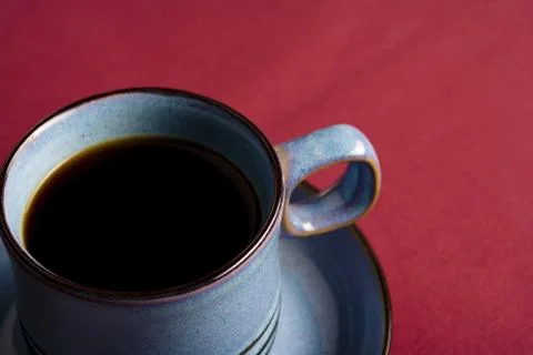 Coffee mug on red tablecloth Stock Photos