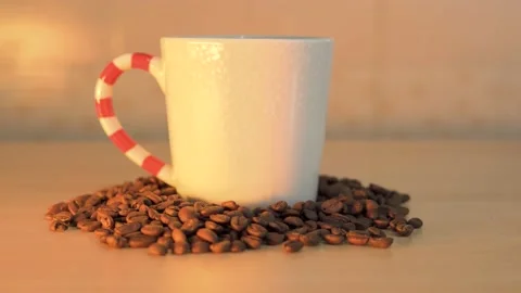 Coffee mug with roasted coffee beans on table Stock Footage 145704363