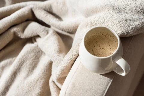 Coffee mug on soft blanket creating cozy morning mood Stock Photos