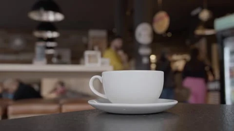 Coffee Mug on Table in Busy Coffee Shop with People Background Stock Footage 274106189