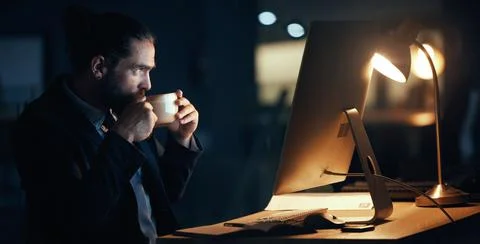 Coffee, night and commitment with a business man working late in a dark office Foto stock