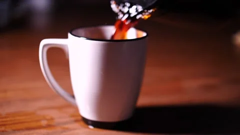 Coffee in an over-filled mug spilling over the sides Stock Footage 153667382