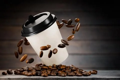 Coffee in a paper cup above the table, roasted coffee beans fly around the .. Stock Illustration