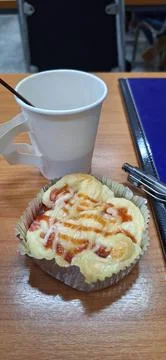 Coffee in a paper cup and bread in the office Stock Photos