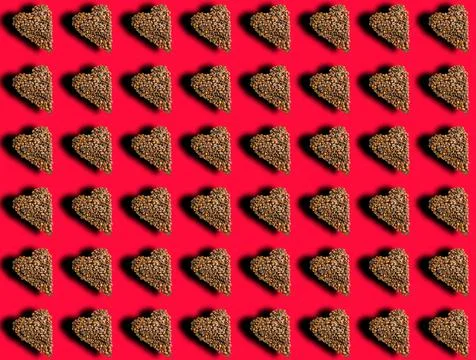 Coffee pattern in the shape of a heart with a shadow on a red background. Fav Foto stock