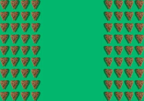 Coffee pattern in the shape of a heart with a shadow on a green background. F Foto stock