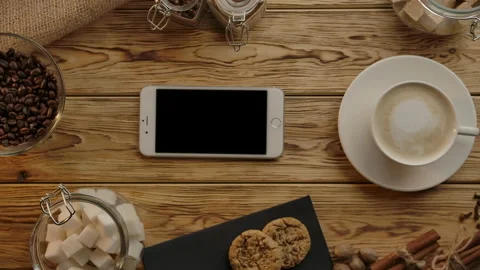 Coffee pause without leaving mobile phone. Drinking cappuccino. Flat lay Stock Footage 136815078