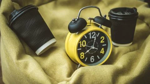Coffee in a plastic cup with retro clock and alarm clock,close-up. Stock Photos