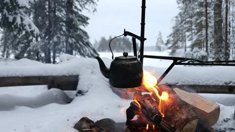 Coffee pot hanging over the fire outside in the winter forest. Stock Footage 147046064
