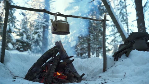 Coffee pot hanging over the fire outside in the winter forest Video stock 148150605