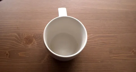 Coffee pot serving a cup of coffee on a wooden background Stock Footage 128979087