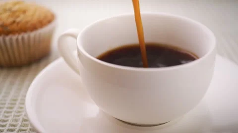 Coffee is poured into a ceramic cup. Stock Footage 279347505