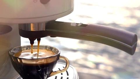 Coffee is poured from a coffee machine into a coffee cup. Video stock 99554890