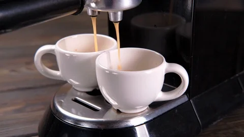 Coffee is poured from a coffee machine into two cups Stock Footage 111922761