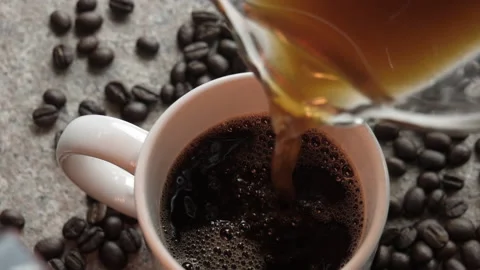 Coffee poured into a cup and beans scattered around Stock Footage 239015803