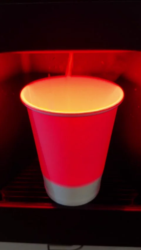 Coffee is poured into a red cup in a backlit coffee machine, vertical video Stock Footage 270036903
