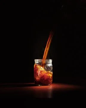 Coffee is poured into a transparent jar. product photography of coffee. Stock Photos