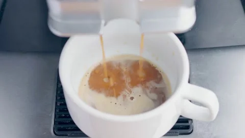 Coffee is poured into a white cup from the coffee machine. making coffee at home Stock Footage 164594535