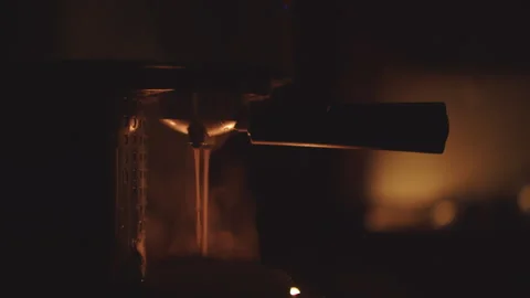 Coffee pouring from a coffee machine on a dark background Stock Footage 261361788