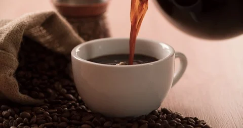 Coffee pouring from coffee pot with scattered coffee beans Stock Footage 98264785