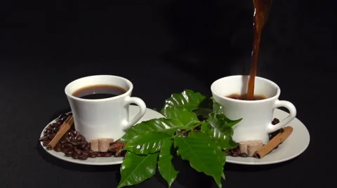Coffee. pouring the coffee into two cups white on a black background. Stock Footage 61197564
