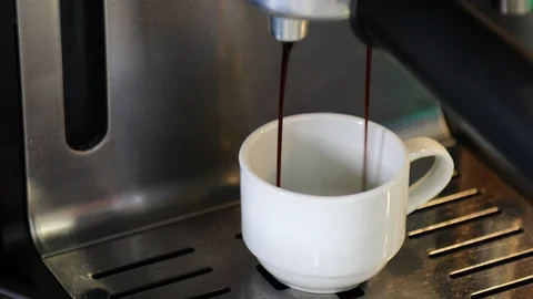 An coffee pouring in to a cup from a coffee machine.  Stock Footage 105017564