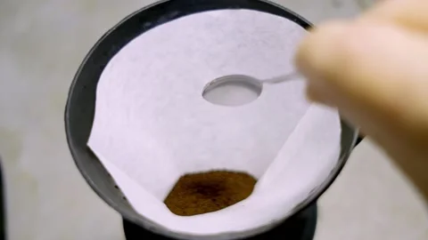 COFFEE POWDER BEING PUT INTO FILTER PAPER Stock Footage 150337488
