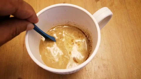 Coffee powder mixed with hot water in a white cup for drinks in the morning. Sel Stock Footage 131295953