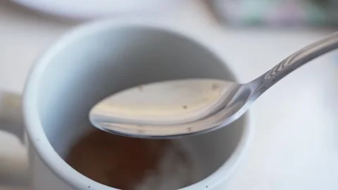 Coffee preparation with silver spoon in cozy kitchen setting Vidéo 329071377